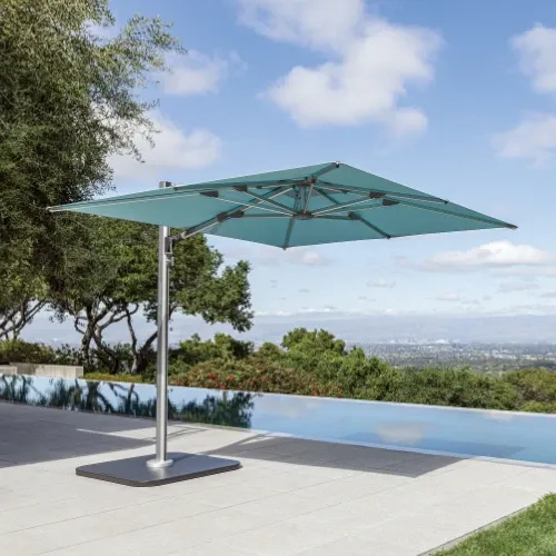 Offset patio umbrella with square teal canopy and aluminum frame next to an infinity pool