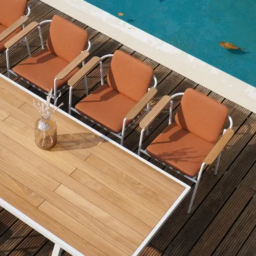 Rectangular teak patio dining table with white frame and armchairs with terracotta cushions