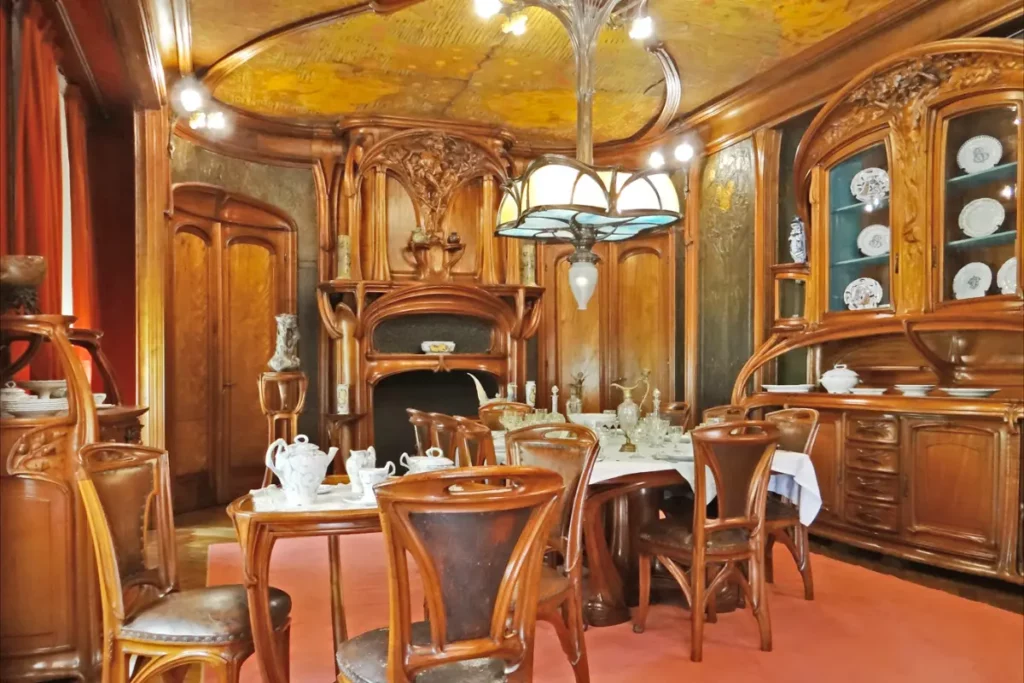 Dining room with gently curving wooden architectural accents with ornate carvings and furniture inspired by nature