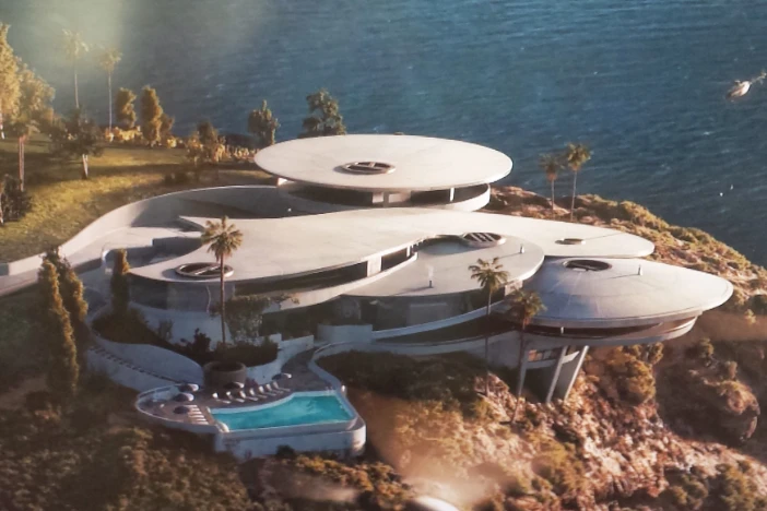 Overhead view of an ultramodern mansion with multi-layered circular sections on a cliffside overlooking water