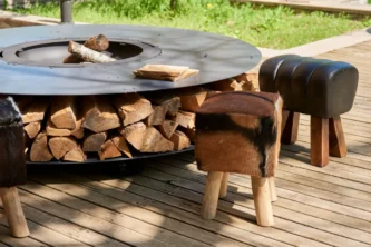 Black cast iron fire pit table with stout leather and cowhide stools on a hardwood deck