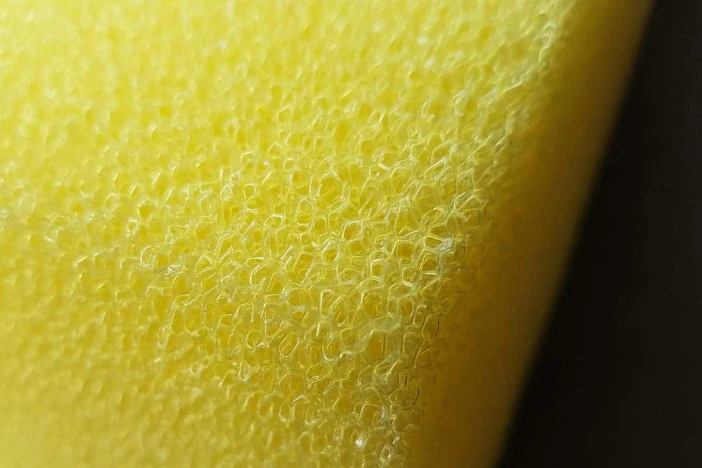 Close-up of the edge of a yellow open-cell foam insert