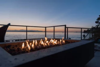 Gas lit rectangular outdoor fire pit on a beach house patio at sunset