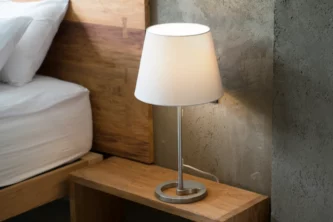 Minimalist modern metal table lamp with tapered white shade on wooden nightstand