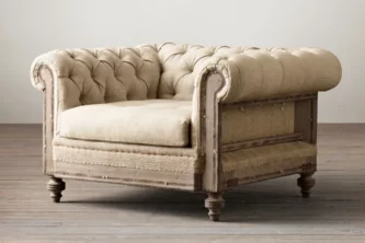 Deconstructed lounge chairs with beige tufted upholstery, distressed wood frame and burlap accents on hardwood floor