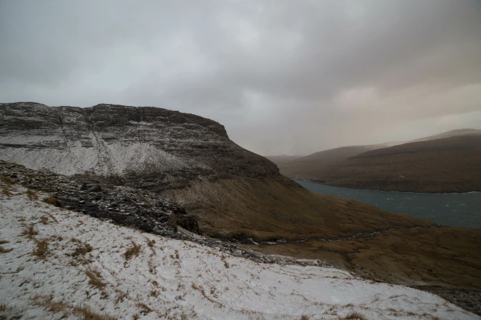 Desolate Danish landscape during winter with snow, hills and a fjord