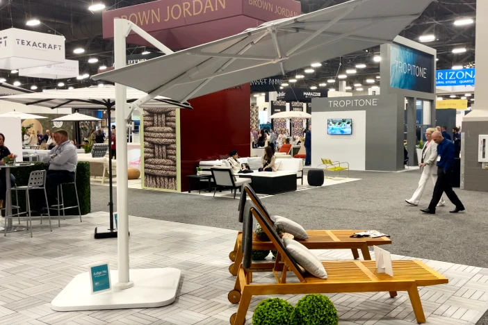 Interior designer trade show with people looking at patio umbrellas and outdoor furniture