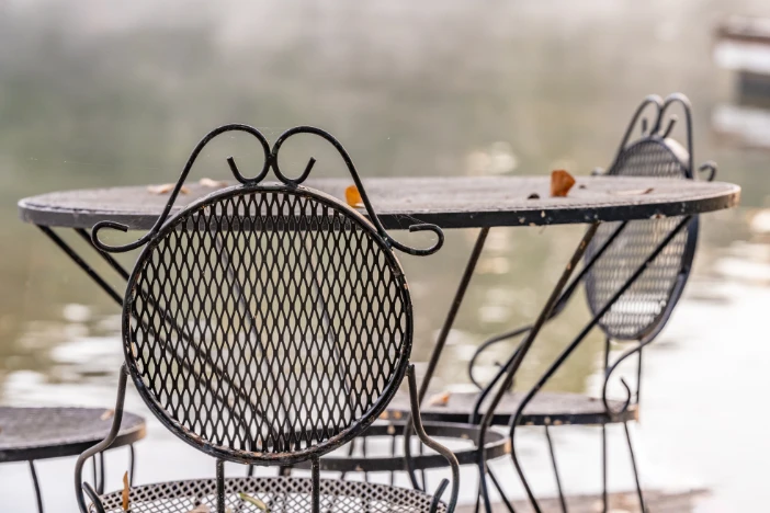 Round wrought iron table and chairs with rusted surfaces