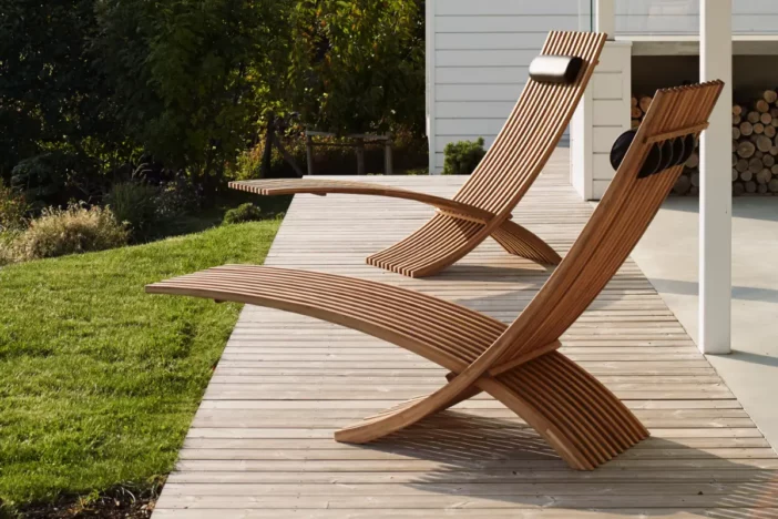 Modern abstract chaise loungers made of teak slats on a wooden deck