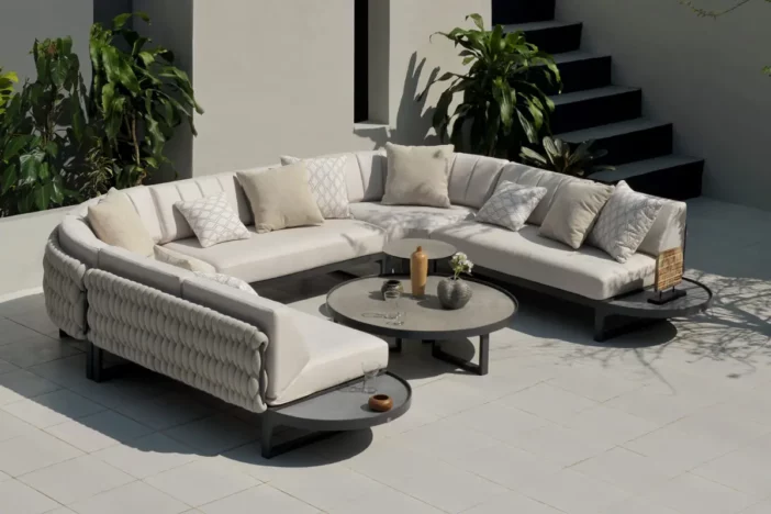 Modern U-shaped patio sectional with beige upholstery and dark taupe tables