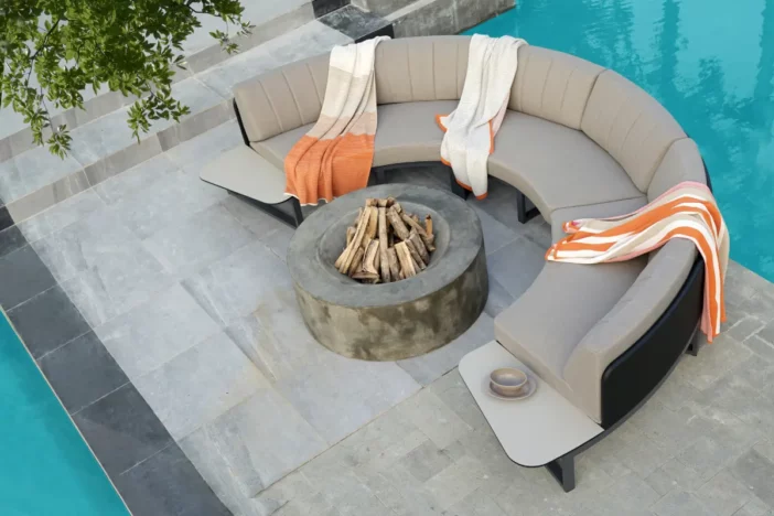 Semi-circular patio sectional with taupe upholstery around a concrete fire pit
