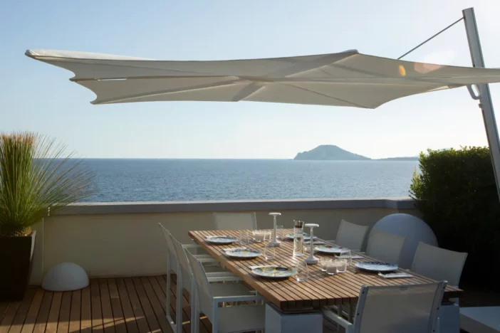 White cantilever umbrella over an outdoor dining table with place settings