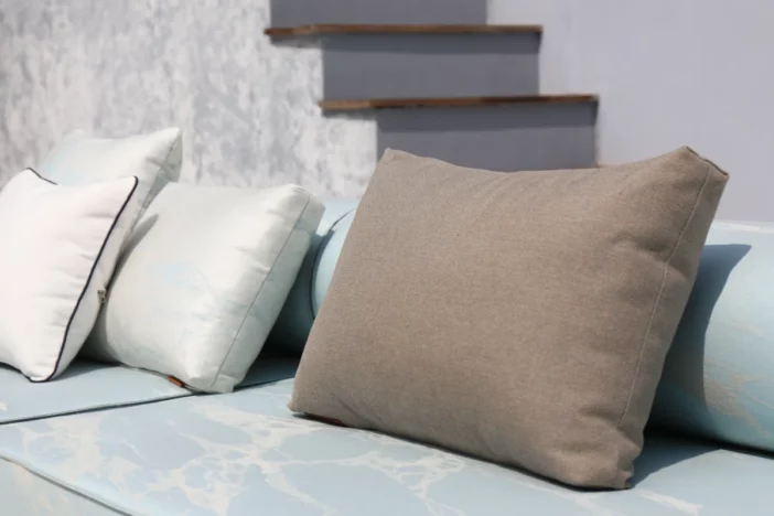 Close-up of marbled light blue outdoor upholstery with white and brown accent pillows