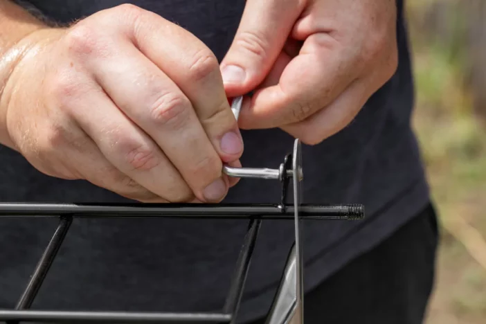 Close-up of hands tightening the screws of outdoor furniture frames