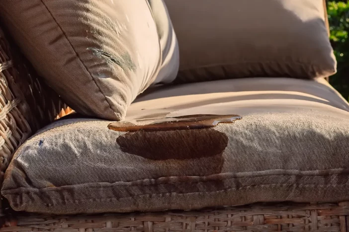 Close-up of backyard wicker seat with a spill on brown cushions