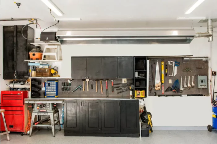 Long gas heater suspended from the ceiling of a garage with pegboard of tools