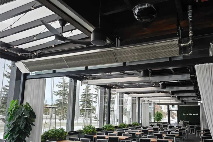 Natural gas heaters mounted on a black pergola over many dining sets