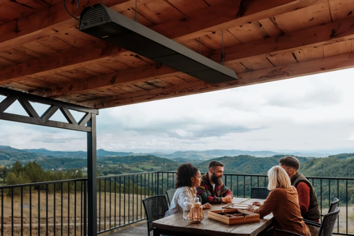 Long black gas patio heater suspended from the wooden cover of a deck