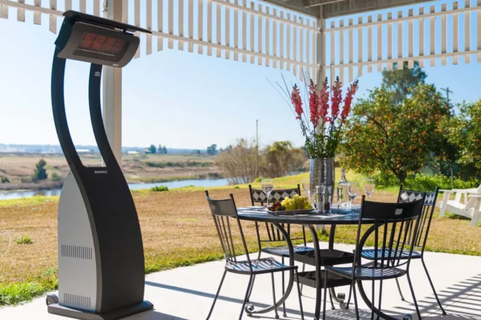 Modern freestanding propane heater next to a dining set on a covered patio