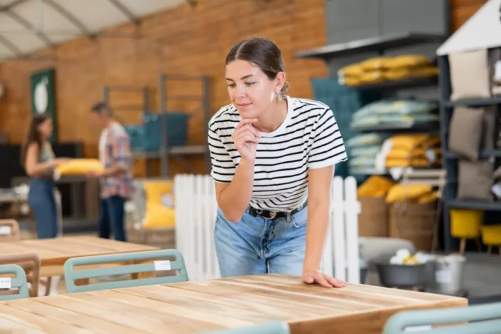 Causally dress woman evaluating outdoor furniture in a store