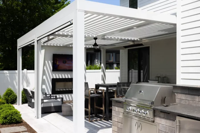 White contemporary louvered pergola with integrated heaters sliding shade screens