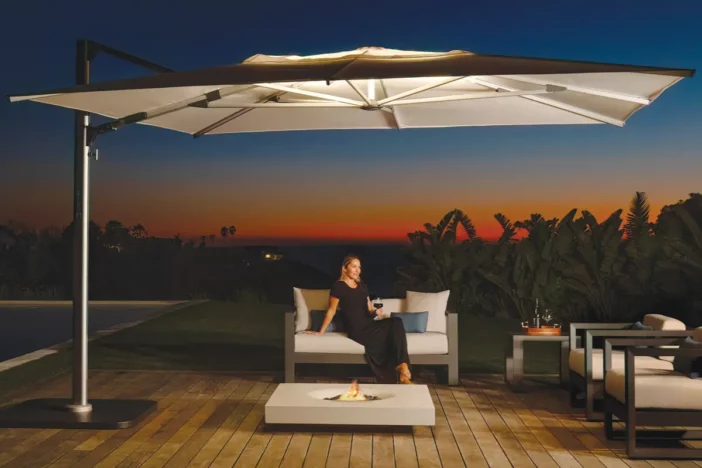 Cantilever umbrella with integrated LED uplighting over a hardwood deck lounge set