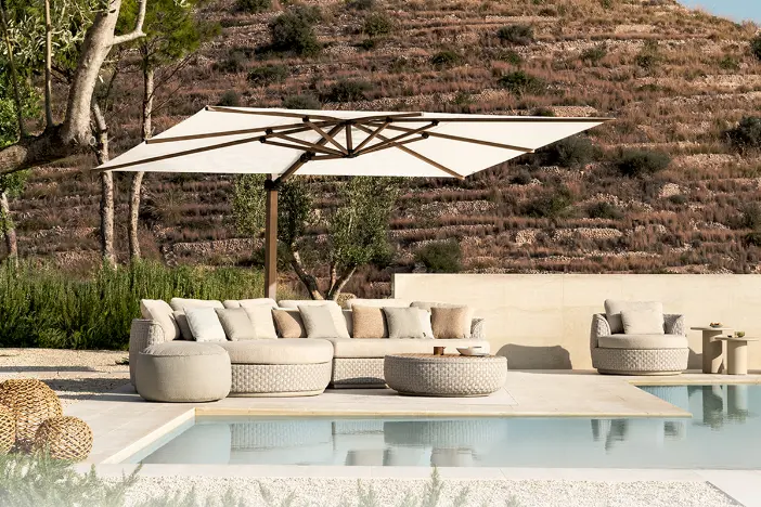 Wood finished cantilever umbrella with white rectangular canopy over a wicker lounge set