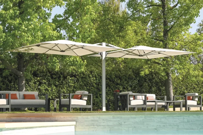 Dual-canopy cantilever umbrella with silver frame and square white canopies poolside