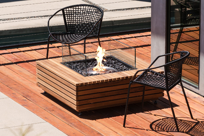 Square teak EcoSmart Fire fire pit table with ethanol burner and glass windscreen on a deck
