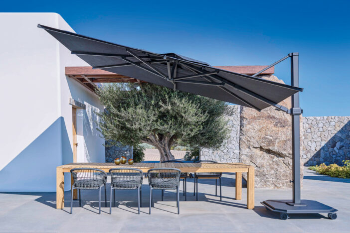 Dark grey cantilever umbrellas with rectangular canopy shading a dining set on a patio