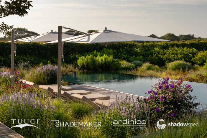 Two modern cantilever umbrellas with square off-white canopies shade sunloungers poolside