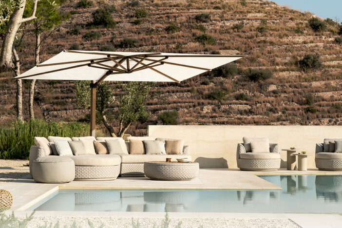 Sleek cantilever umbrella with woodgrain frame and white rectangular canopy shading woven lounge seating poolside